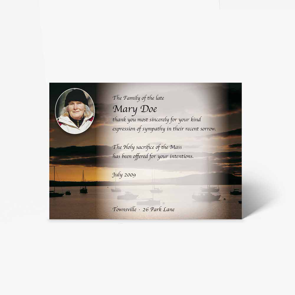 a funeral card with a photo of a boat and a sunset