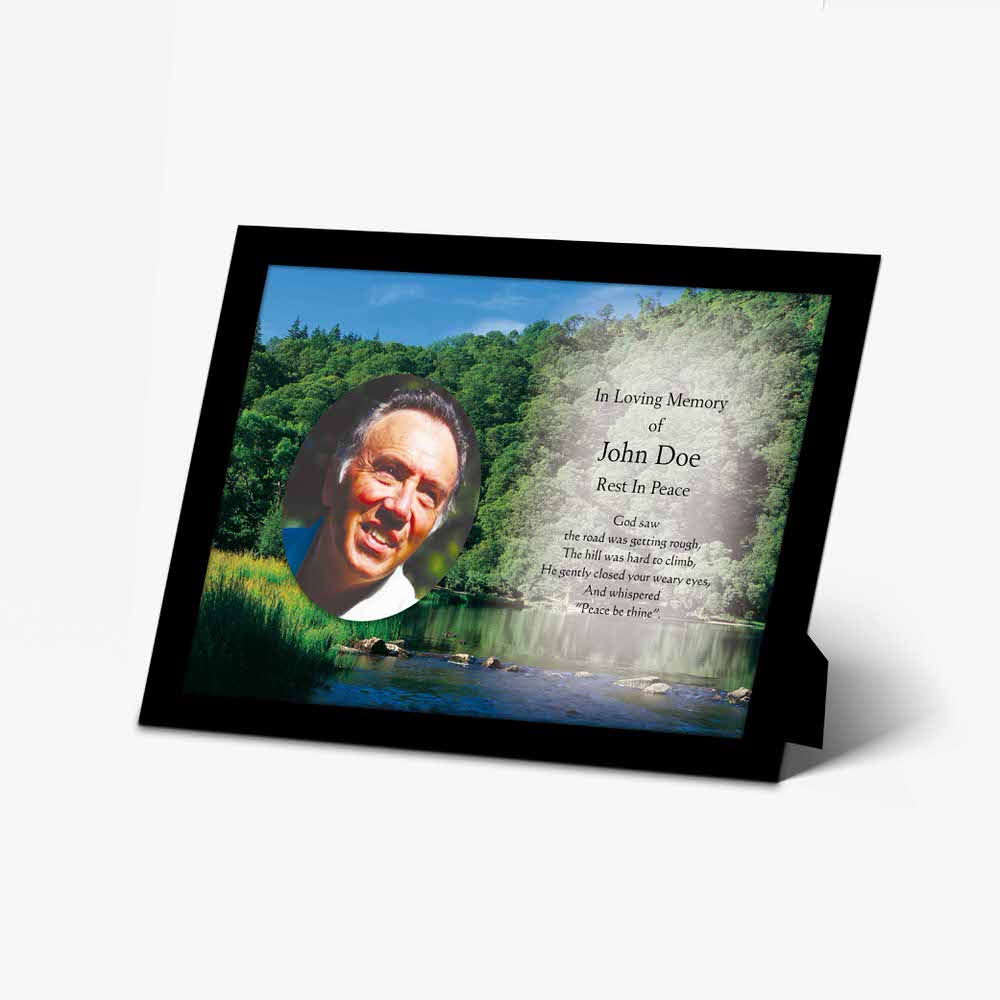 a memorial plaque with a photo of a man in a forest