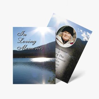 a funeral card with a photo of a lake and a sun