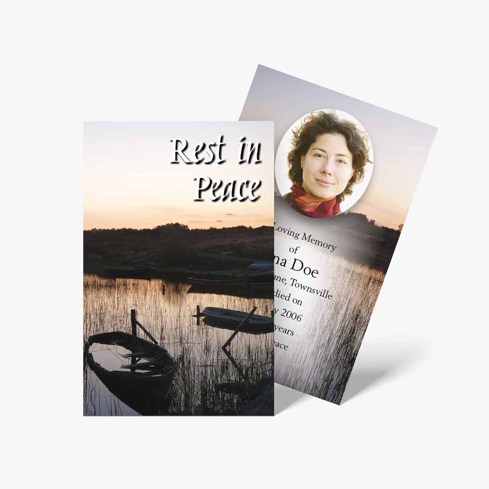 a funeral card with a photo of a boat and a sunset