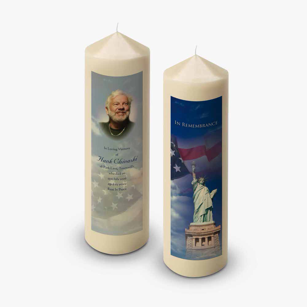 a memorial candle with a statue of liberty and the american flag