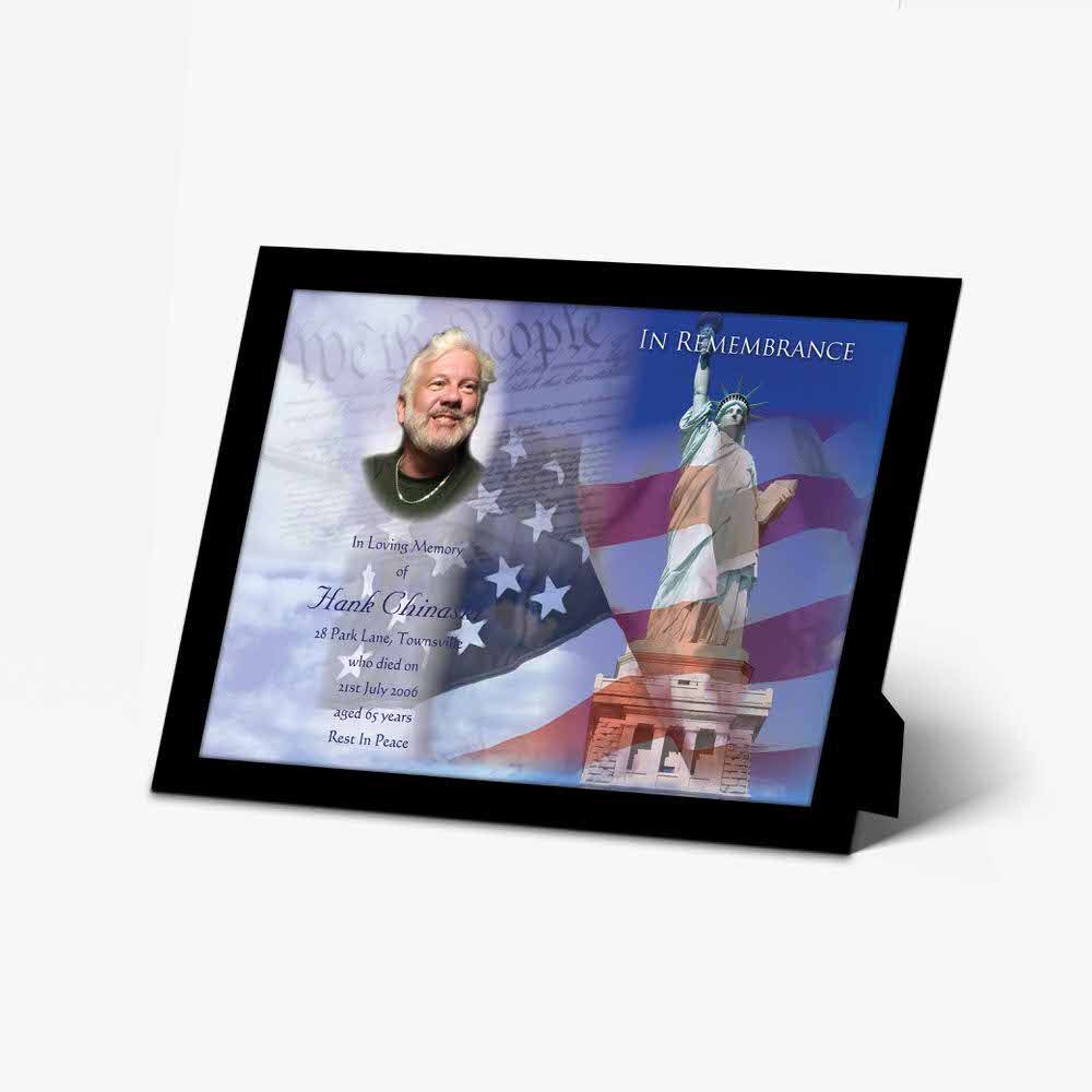 a memorial plaque with a statue of liberty and an american flag