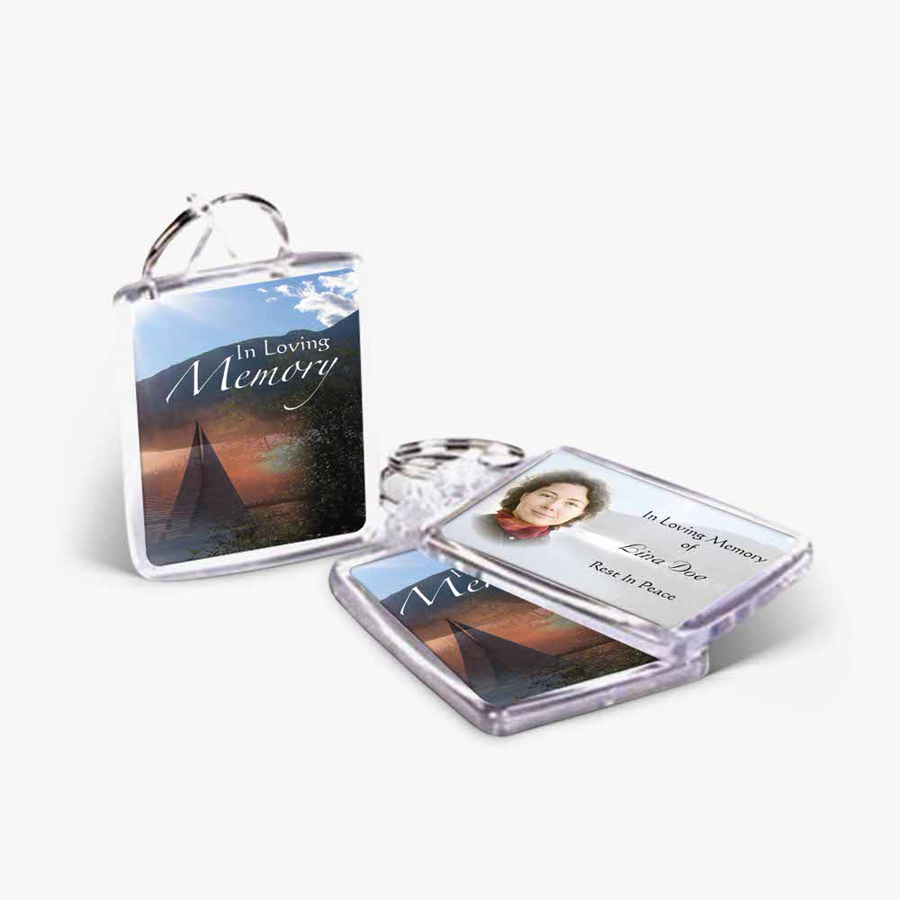 a keychain with a photo of a mountain and a photo of a person