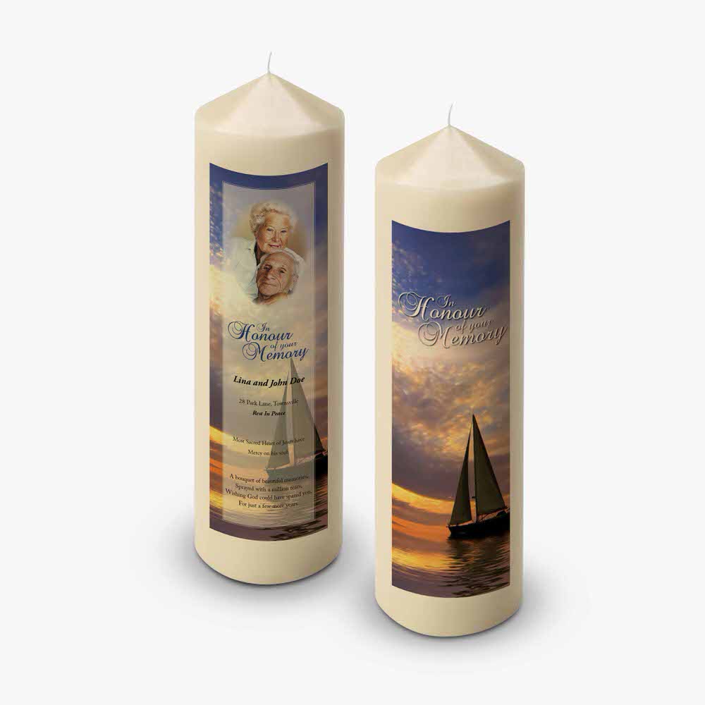 two candles with a photo of a sailboat on them