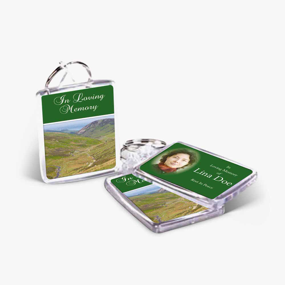 a keychain with a photo of a green field and a photo of a person