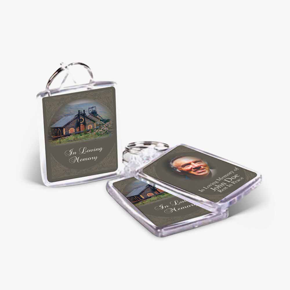 two small key chains with a photo of a house