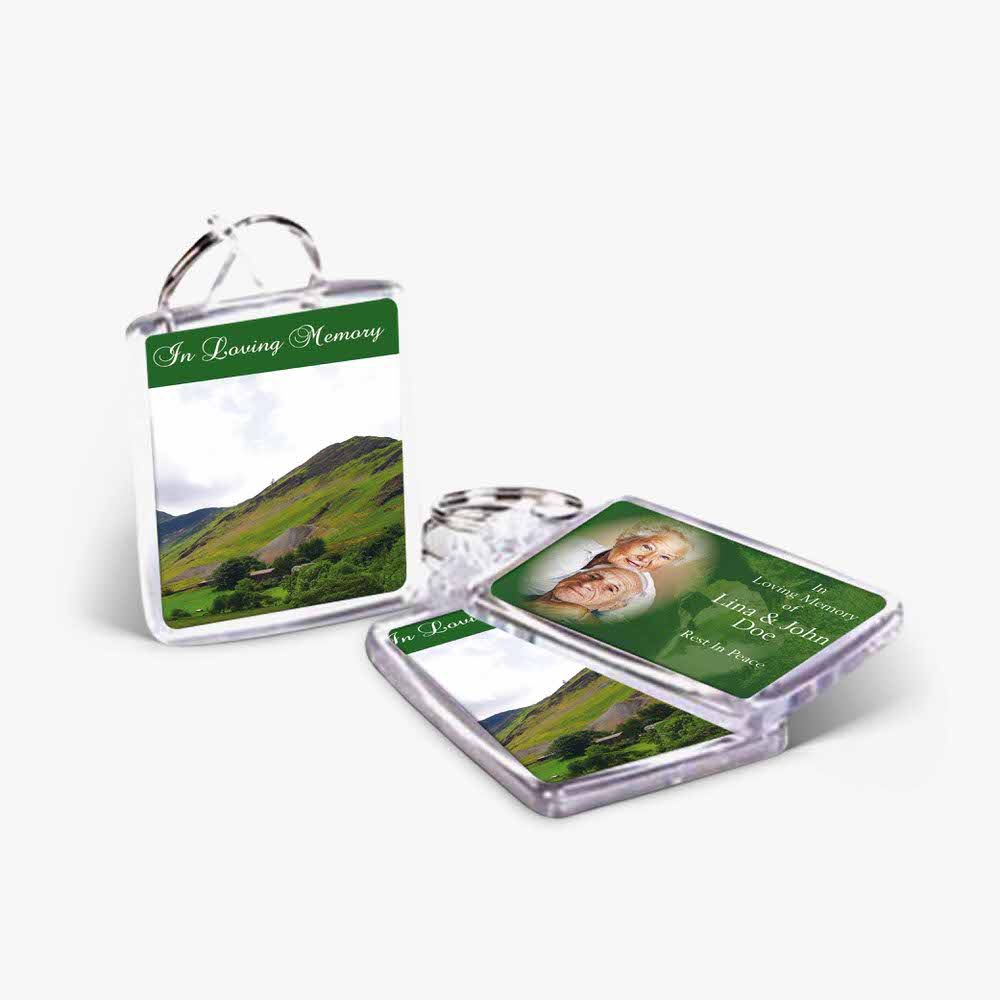 a keyring with a photo of a green hill and a photo of a person