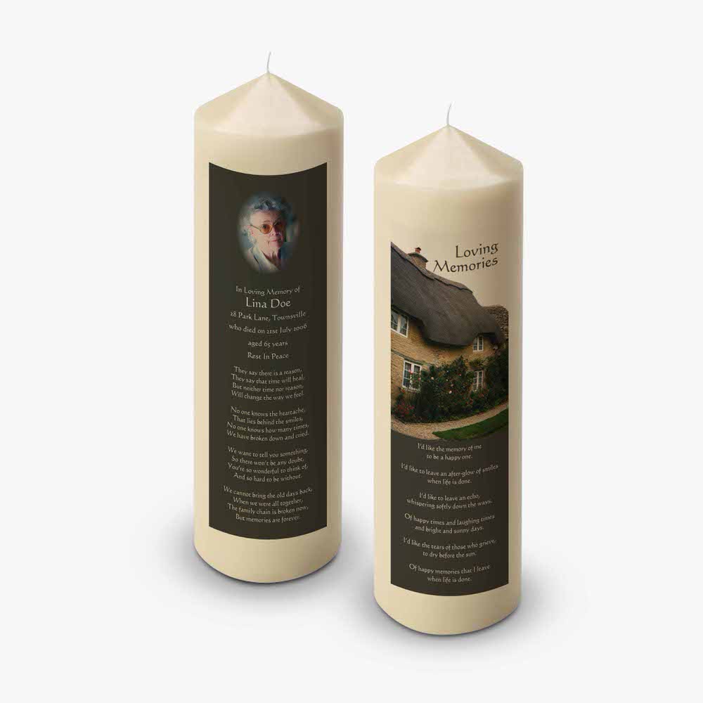 two candles with a picture of a house on them