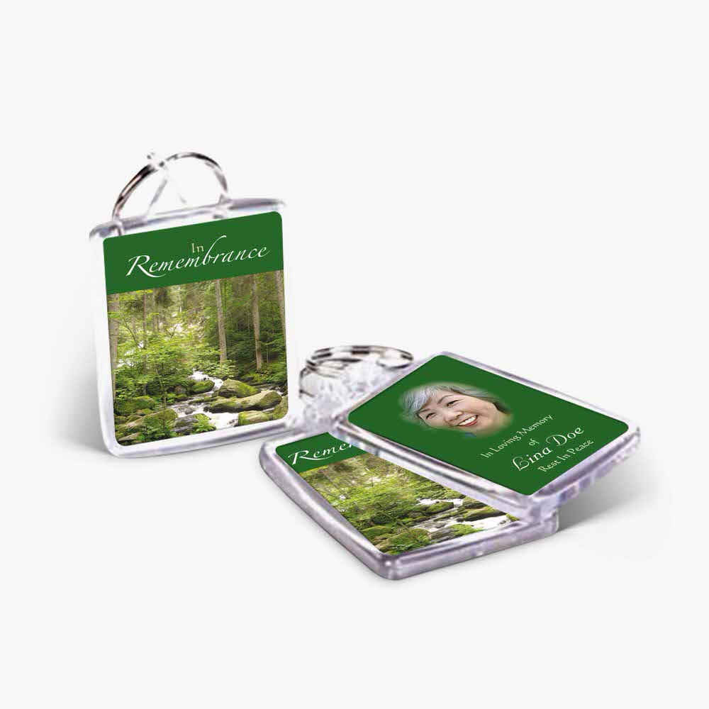 two key chains with a photo of a forest and a waterfall