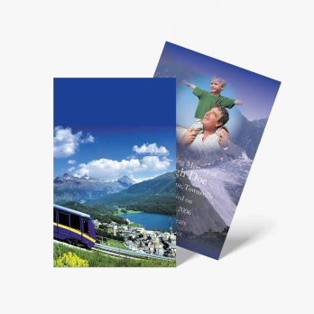 two brochures with a train and mountains in the background