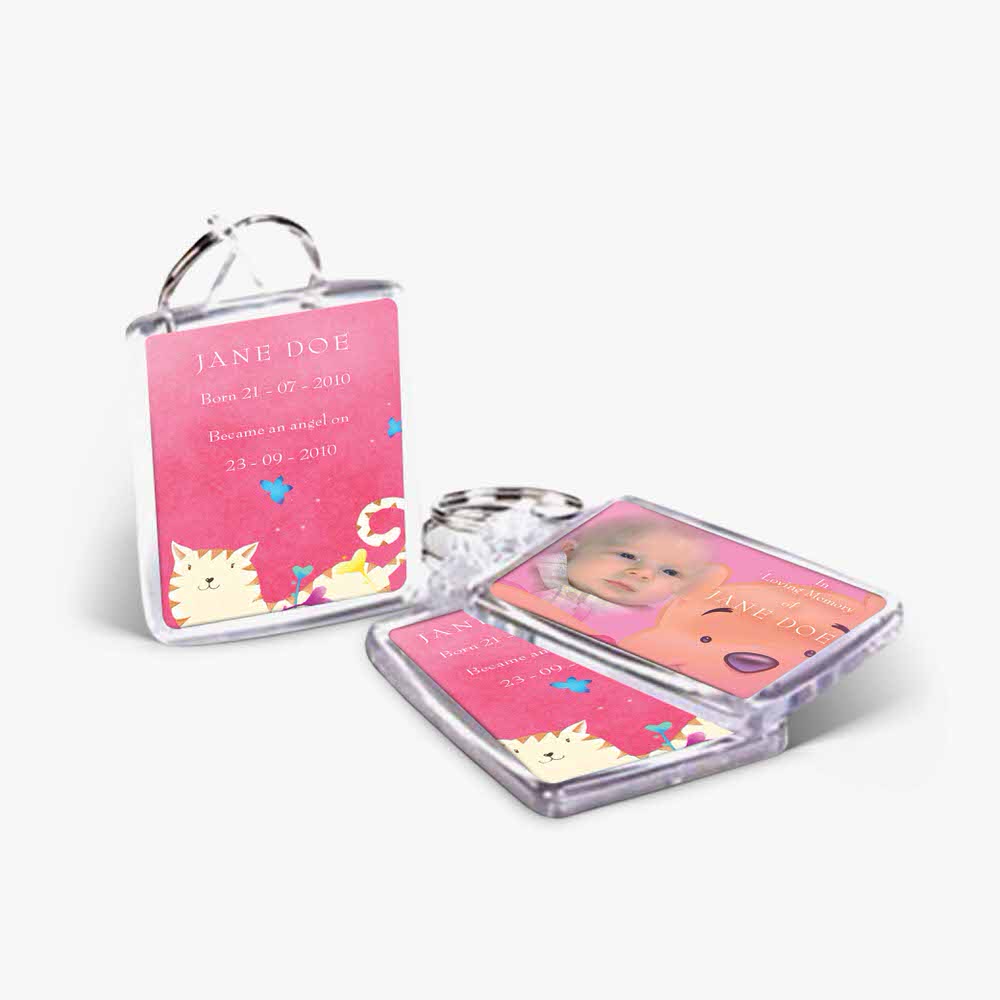 a pink keychain with a picture of a cat and a baby