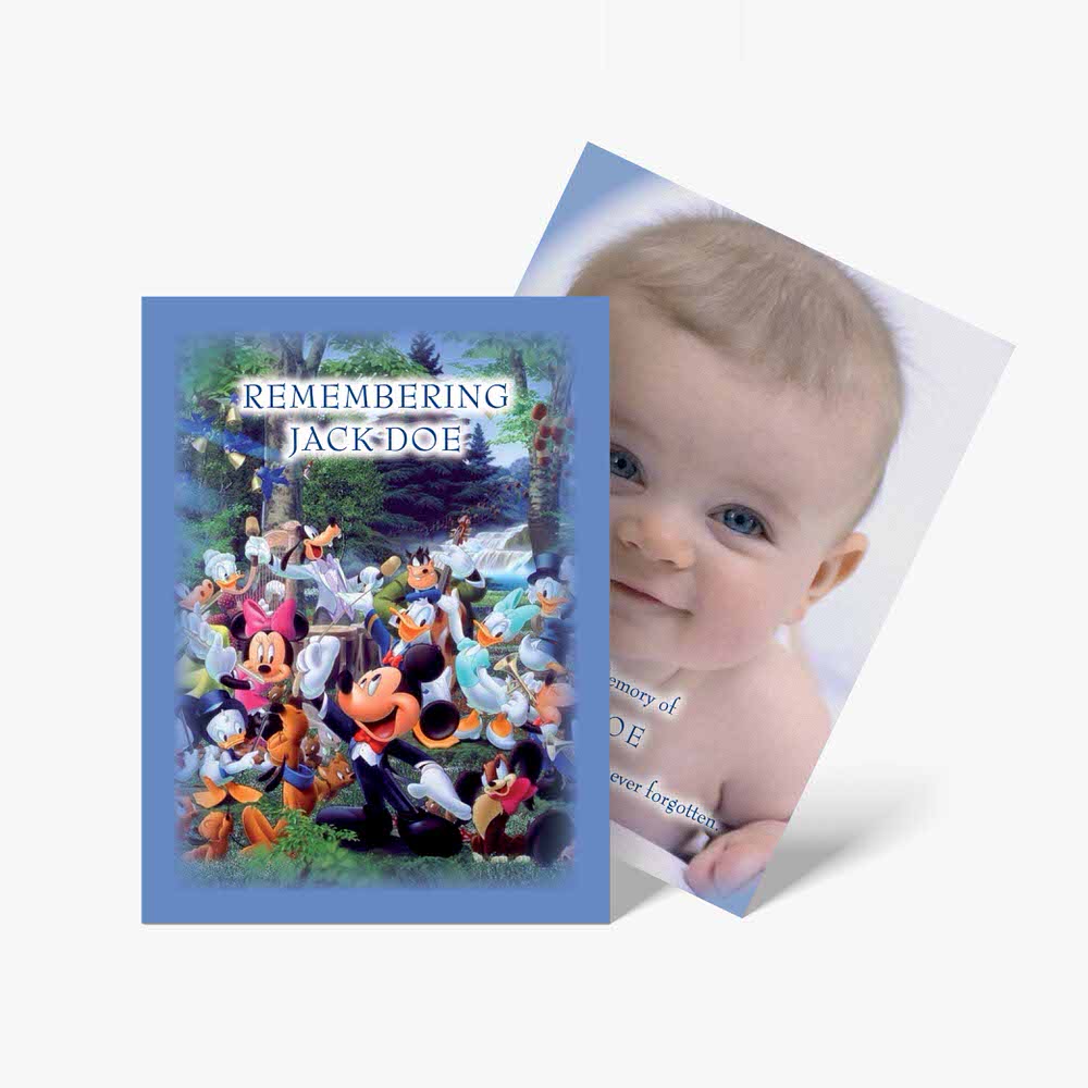 a baby is smiling in front of a blue card with a picture of mickey mouse and friends