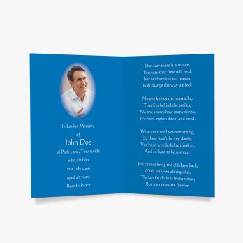 a blue funeral card with a photo of a man in a blue suit