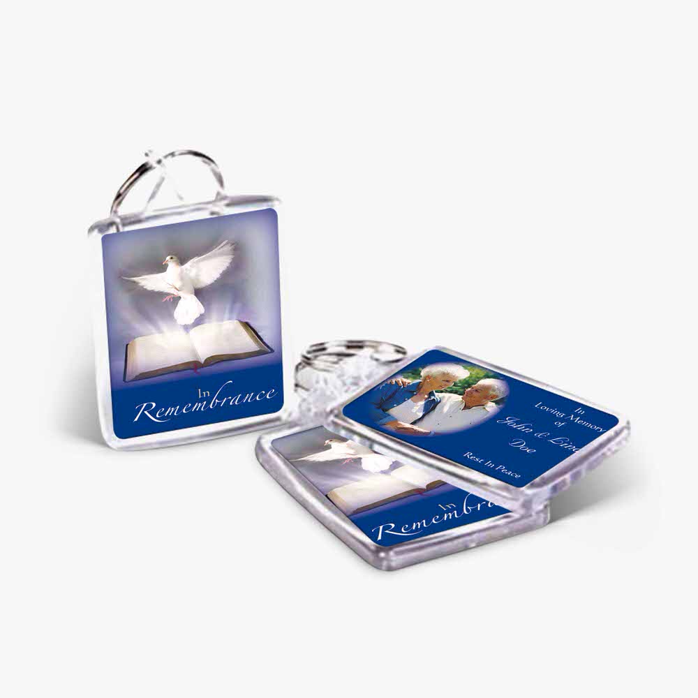 a key chain with a picture of a dove and a book