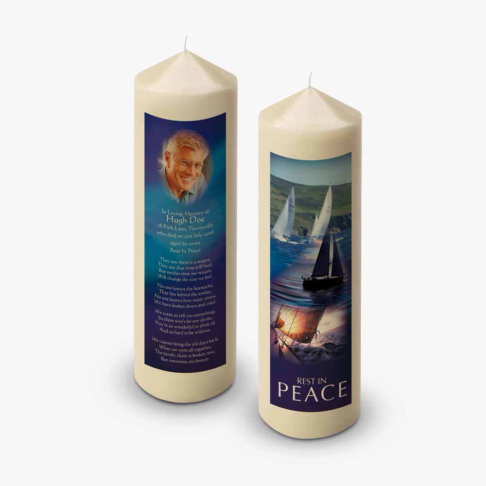two candles with a picture of a sailboat on them