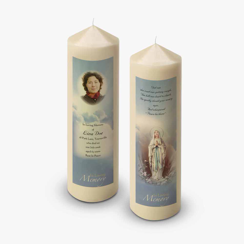 two candles with a picture of mary and a prayer