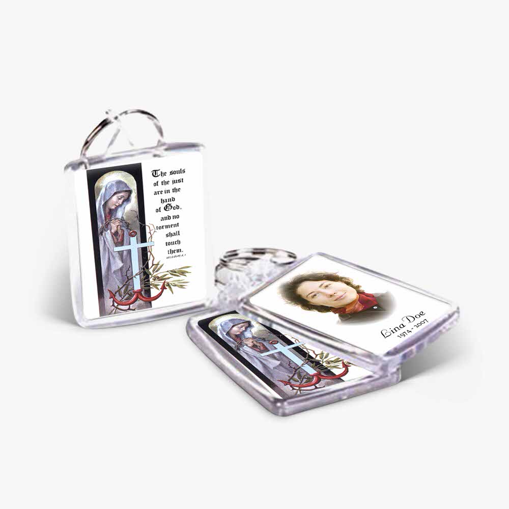 a small key chain with a picture of a saint and a cross