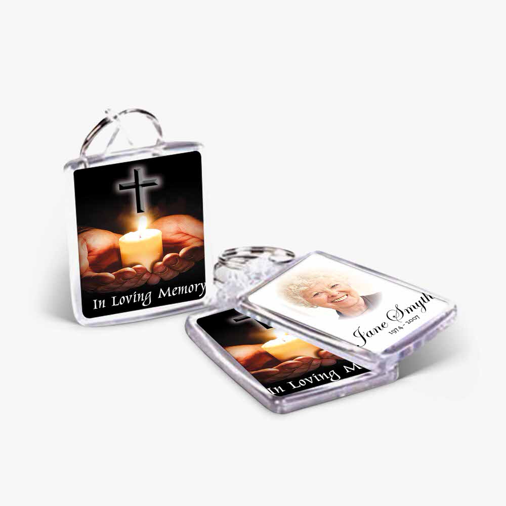 a keychain with a photo of a candle and a cross