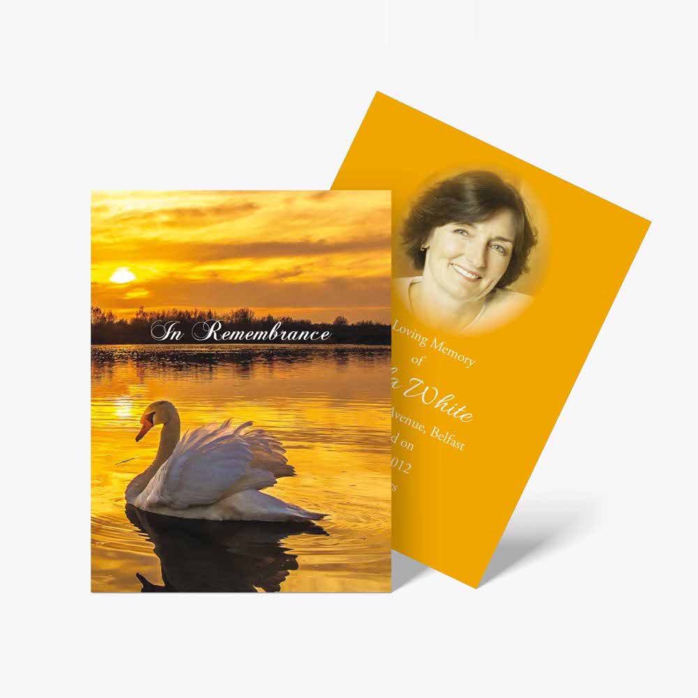 a memorial card with a swan and a sunset